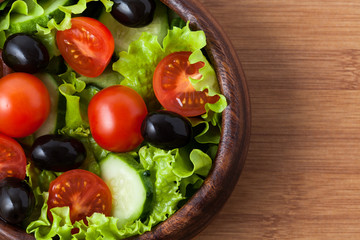 Salad on wooden plate.