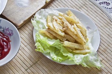French fries on plate on wooden table