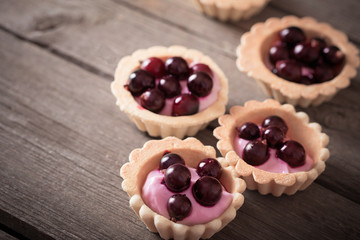 cakes with berries on wooden background