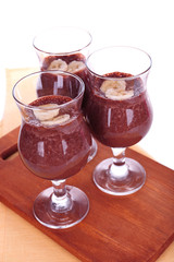 Cocktails with banana and chocolate on table on white