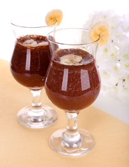 Cocktails with banana and chocolate on table on white