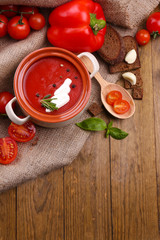 Tasty tomato soup and vegetables on wooden table