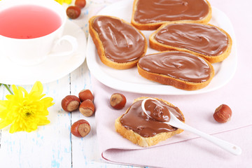 Bread with sweet chocolate hazelnut spread on plate on table