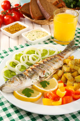 Delicious grilled fish on plate on table close-up