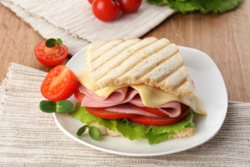 Tasty sandwich with ham on wooden table
