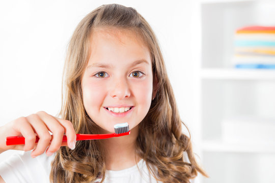Closeup of young girl brushing teeth
