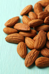 Almonds on color wooden background