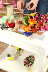 Female hands composing beautiful bouquet, close-up. Florist at