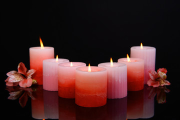 Beautiful candles with flowers isolated on black