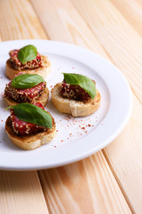 Tasty canapes with salami  and basil leaves,