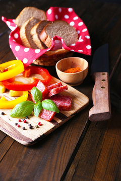 Composition with knife,  tasty salami sausage, sliced bread and