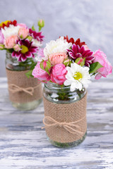 Beautiful bouquet of bright flowers in jars