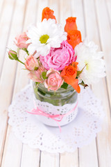 Beautiful bouquet of bright flowers in jars on table close-up
