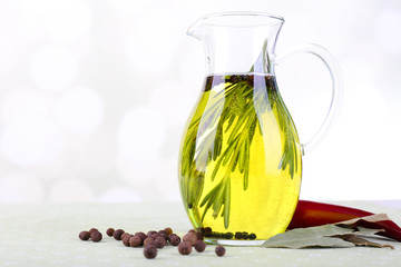 Essential Oil with rosemary in glass jug, isolated on white
