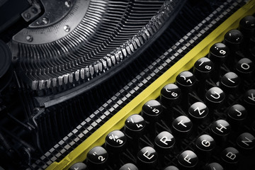 Old yellow typewriter in shadow