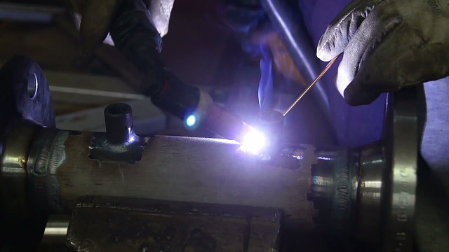 Welder, working on the center ring of a large metal part