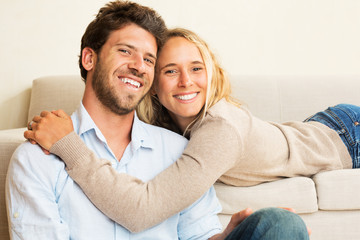 Happy young couple at home on sofa