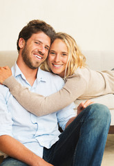Happy young couple at home on sofa