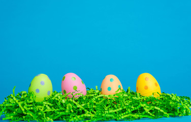 4 assorted color Easter eggs on a bright blue background