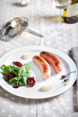 Grilled sausages with salad on a white plate