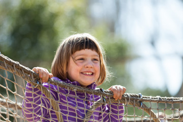  laughing girl climbing on ropes