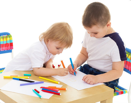 two boys enthusiastically paint markers