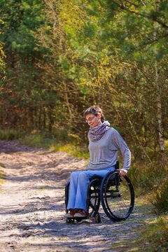 Disabled woman riding a wheelchair in the woods