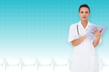 Composite image of pretty nurse using tablet pc