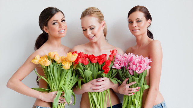 Three beautiful women with fresh spring tulips