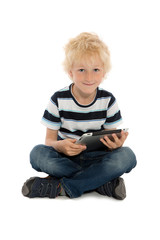 Junge sitzt mit Tablet Computer am Boden