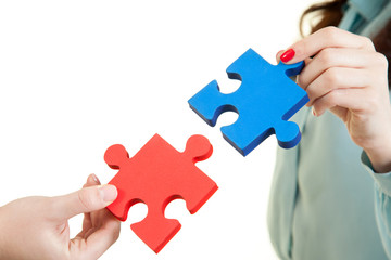 business women assembling jigsaw puzzle and