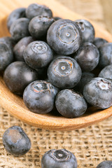 fresh blueberries in a wooden spoon over wooden table