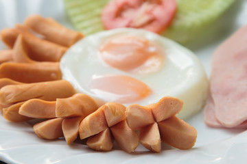 Breakfast with sausage, bacon, fried egg and vegetable