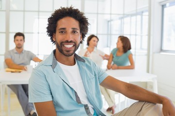 Portrait of a smiling businessman with colleagues in meeting