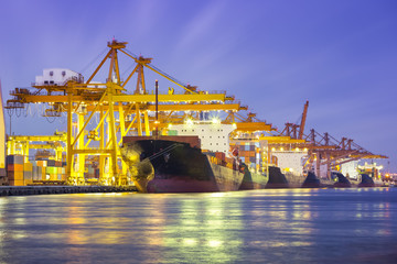 Gantry crane loading and unloading cargo container  from cargo ship at port to show global...