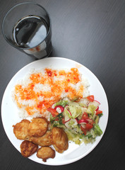 chicken on a plate with rice and salad, shot from above
