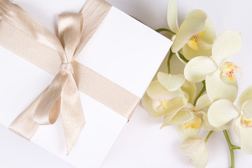 close up of gift box with ribbon and orchid