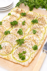 pie with zucchini and herbs on a wooden board