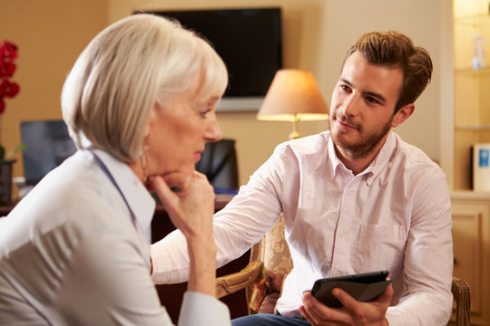 Woman Talking To Male Counsellor Using Digital Tablet