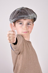 Young boy with a newsboy cap showing a thumb up