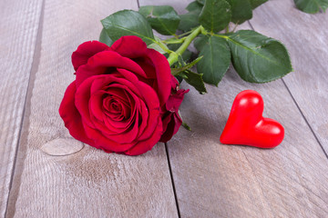 rotes Herz mit roter Rose auf rustikalem Tisch