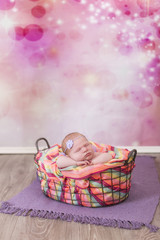 Fototapeta na wymiar Newborn kleines Mädchen in einem Korb sehr bunt