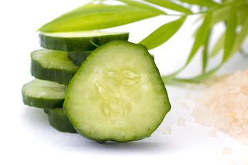 Slices of cucumber with sea salt isolated on white