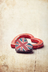 Two hearts - one with Union Jack - on wooden board, vintage styl