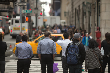 Crowd of anonymous people walking on city street