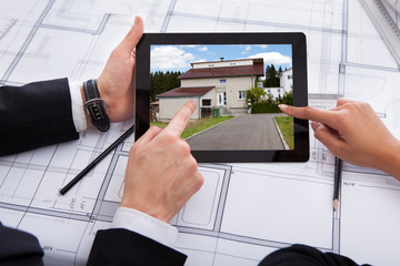 Architects With Digital Tablet Looking At House