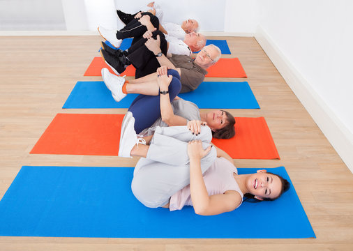 People Exercising On Mats At Gym - Powered by Adobe