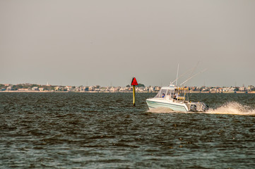 moving fishing power boat in a distance on the ocean