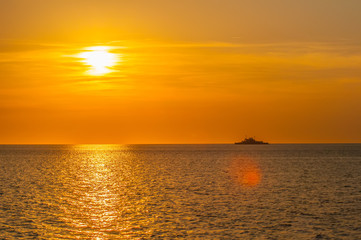 sunset on sea with ferry in distance
