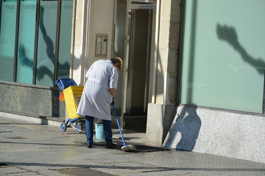 mujer de la limpieza fregando un portal